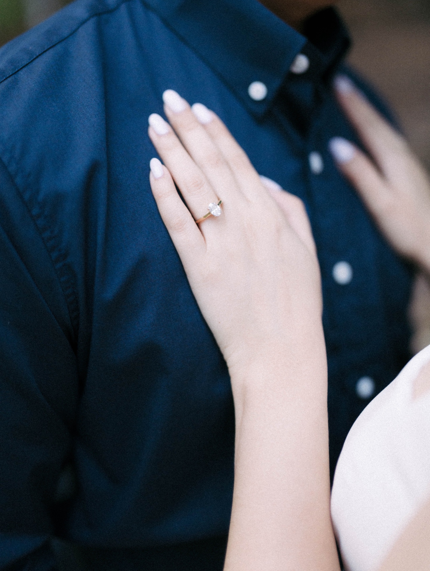 Detalle del anillo de compromiso de Ana sobre la camisa de Dario